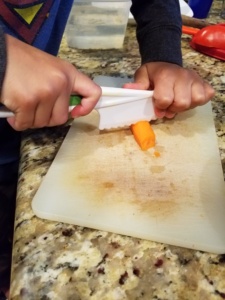 Big Brother using Curious Chef Knife Set in Montessori Inspired kitchen